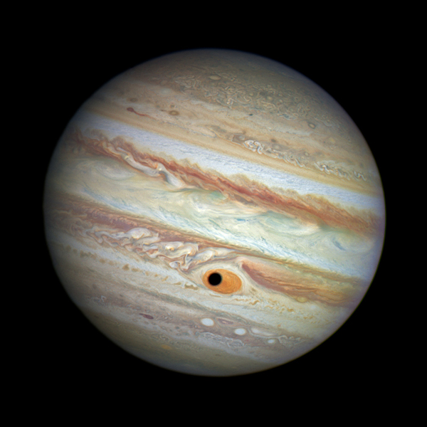 This NASA/ESA Hubble Space Telescope image shows a gorgeous close-up view of the planet Jupiter. Astronomers were using Hubble to monitor changes in Jupiter's immense Great Red Spot (GRS) storm. During the exposures, on 21 April 2014, the shadow of the Jovian moon Ganymede swept across the center of the GRS. Giving the giant planet the uncanny appearance of having a pupil in the center of a 16 000 kilometre wide eye.